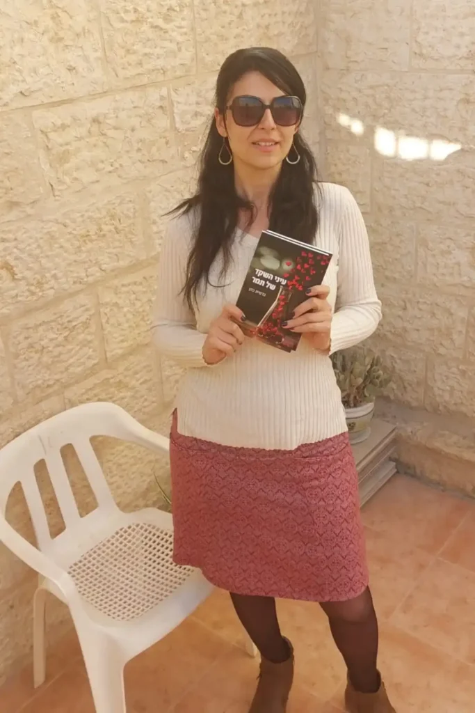 כרמית כהן מחזיקה את ספרה ״עיני השקד של תמר״