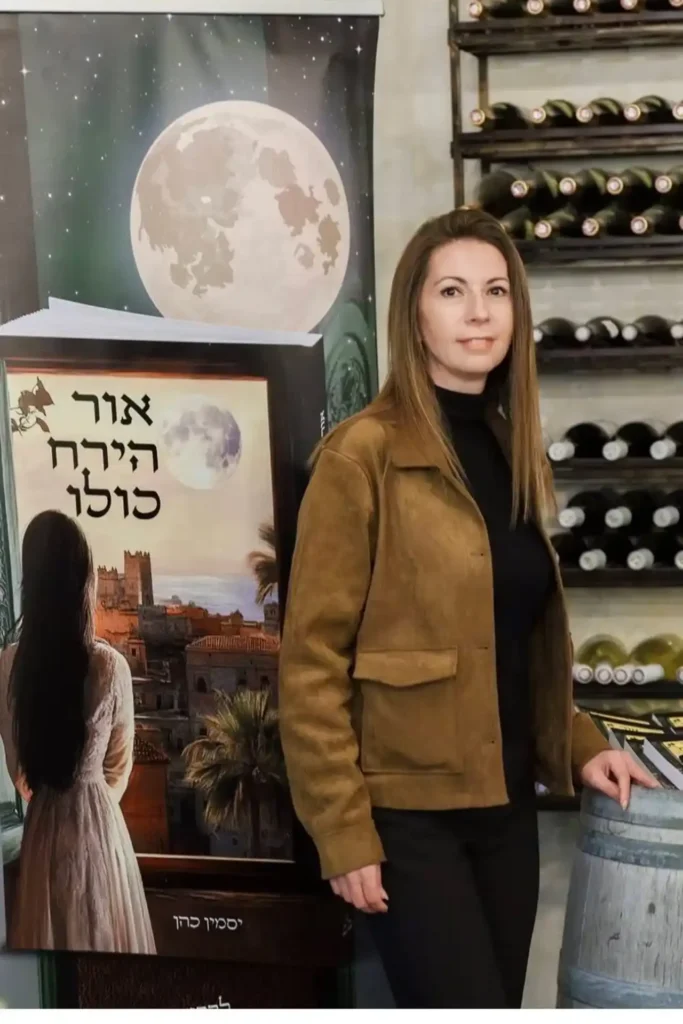 יסמין כהן מחזיקה את ספרה ״אור הירח כולו״